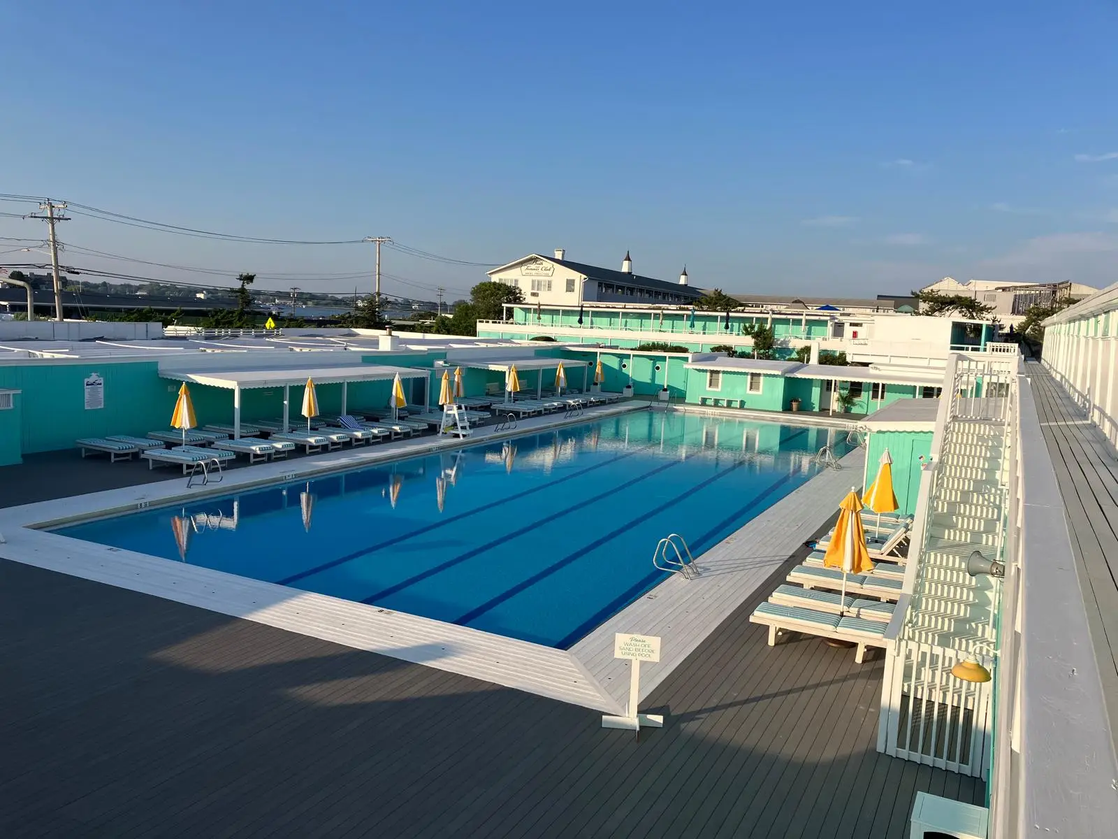 A six-lane outdoor pool with empty loungers. Nobody in frame.